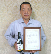 「あした、福の島」と研修受講証を手にする吉田社長