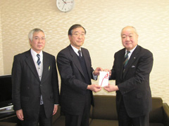 ラジオ福島の本多社長に寄付する小野会長（中央）、左は髙木専務理事