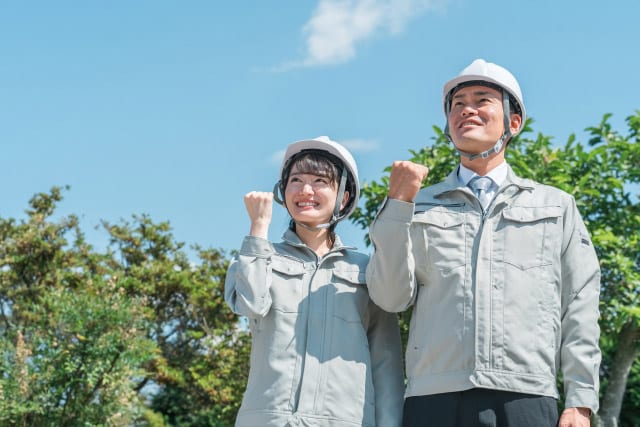 作業着を着てガッツポーズをするスタッフ